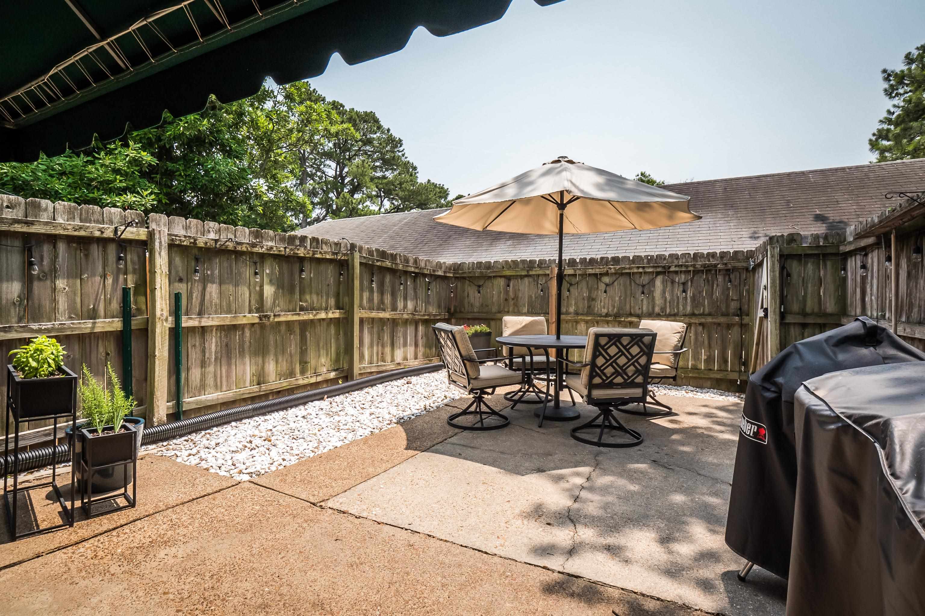 1237 Chamberlain Drive, Unit 1237 Memphis, TN 38119 - Photo 22 of 25 a view of a patio with table and chairs under an umbrella with a small garden
