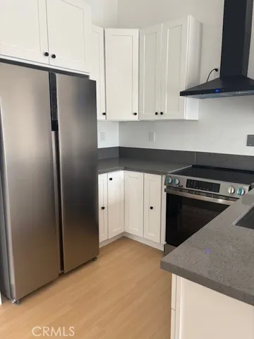 a kitchen with stainless steel appliances granite countertop a refrigerator a stove and a sink