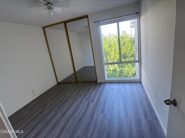 an empty room with wooden floor and a window
