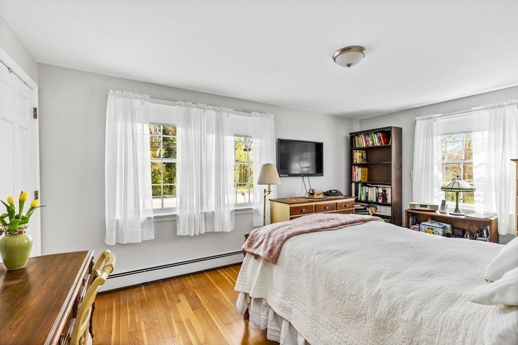 140 Gannett Road Scituate, MA 02066 - Photo 15 of 36 a bedroom with a bed and large windows
