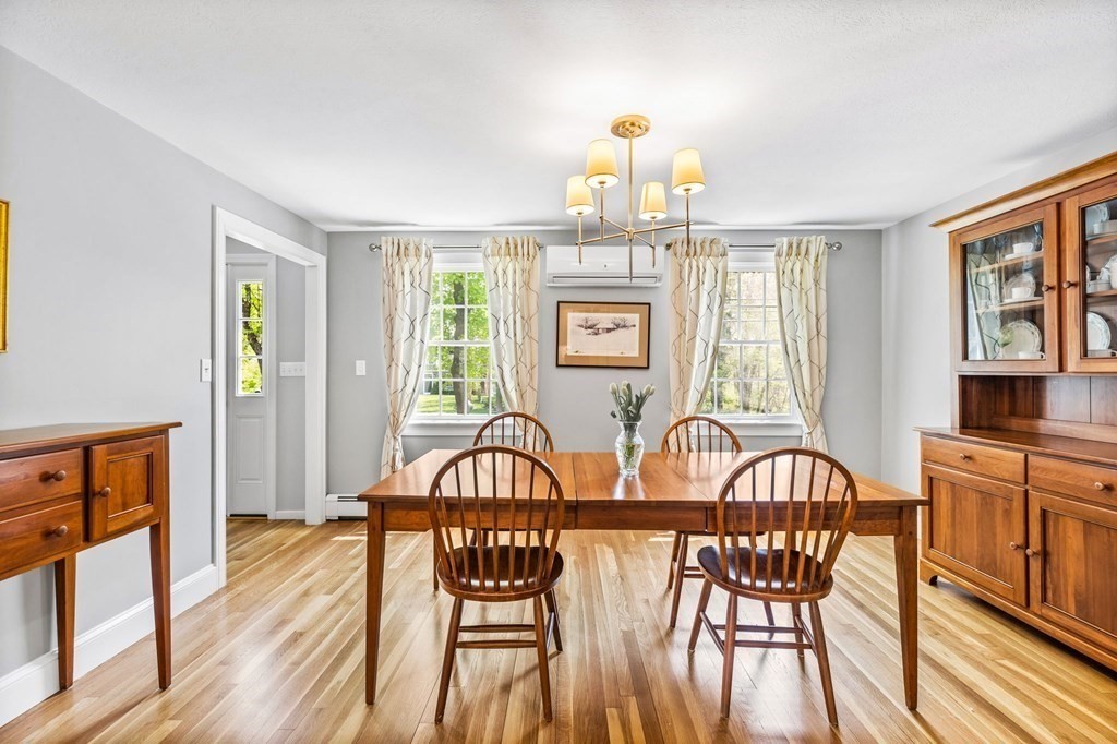 140 Gannett Road Scituate, MA 02066 - Photo 8 of 36 a view of a dining room with furniture a chandelier and wooden floor