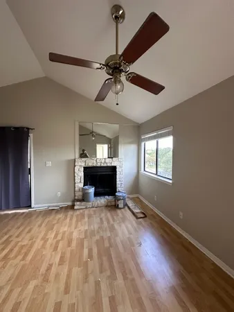 a view of empty room with a fireplace and wooden floor