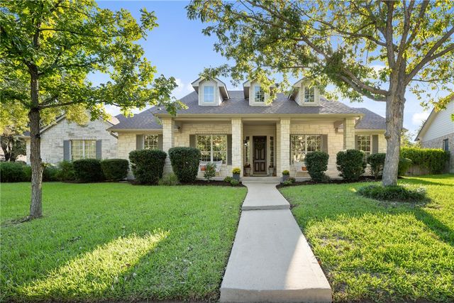 a front view of a house with a yard and potted plants