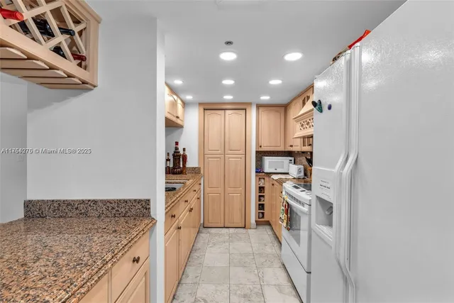 a kitchen with stainless steel appliances granite countertop a refrigerator and a sink