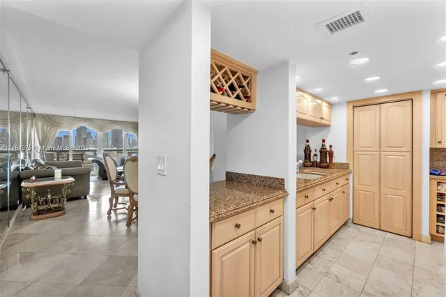 a kitchen with white cabinets and sink