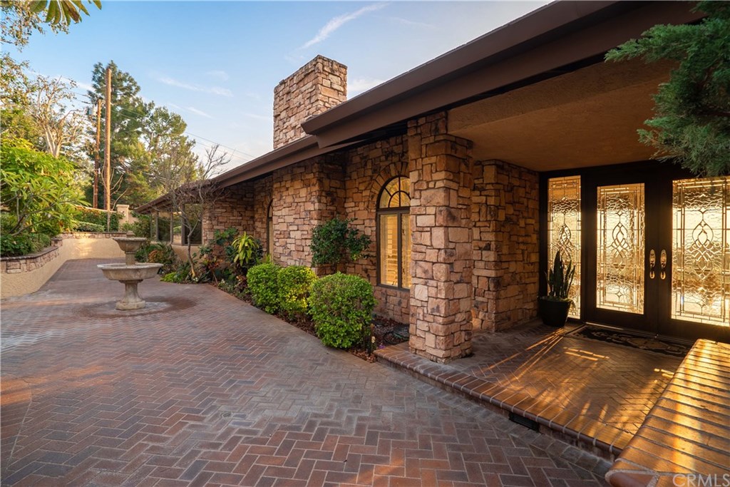 10521 Easter Hill Drive North Tustin, CA 92705 - Photo 6 of 31 Courtyard entry with bricked patio and lush gardens. Custom brick seating area not shown to left of fountain. Beautiful entry doors to home to this unique home.