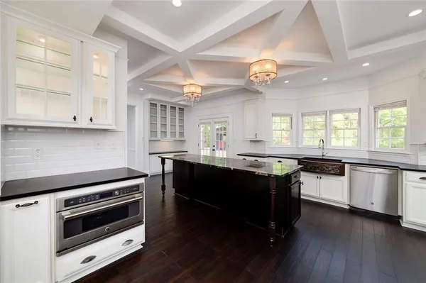 a kitchen with stainless steel appliances a refrigerator a stove and white cabinets