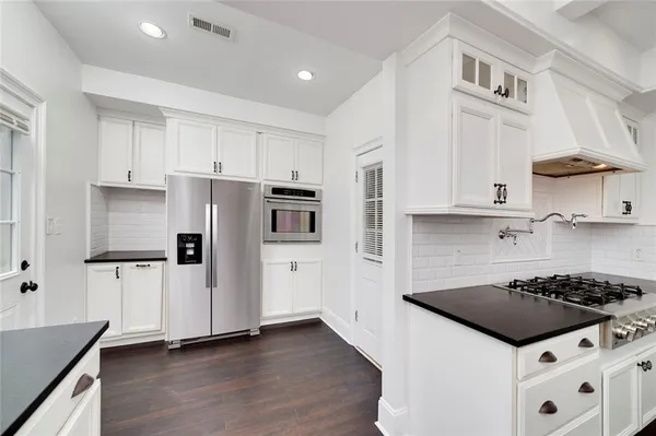 a view of a room with wooden floor and a kitchen