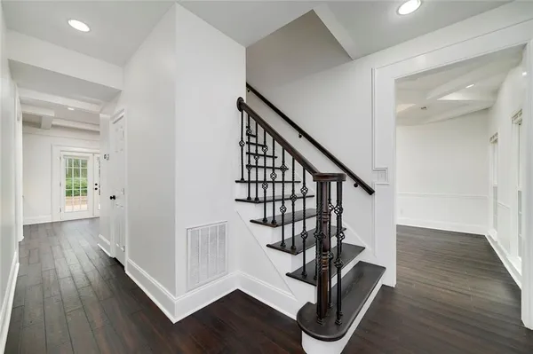 an empty room with wooden floor fireplace and windows
