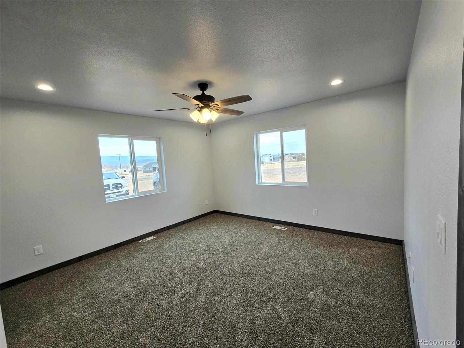 121 Quincy Street Florence, CO 81226 - Photo 12 of 23 an empty room with windows and fan