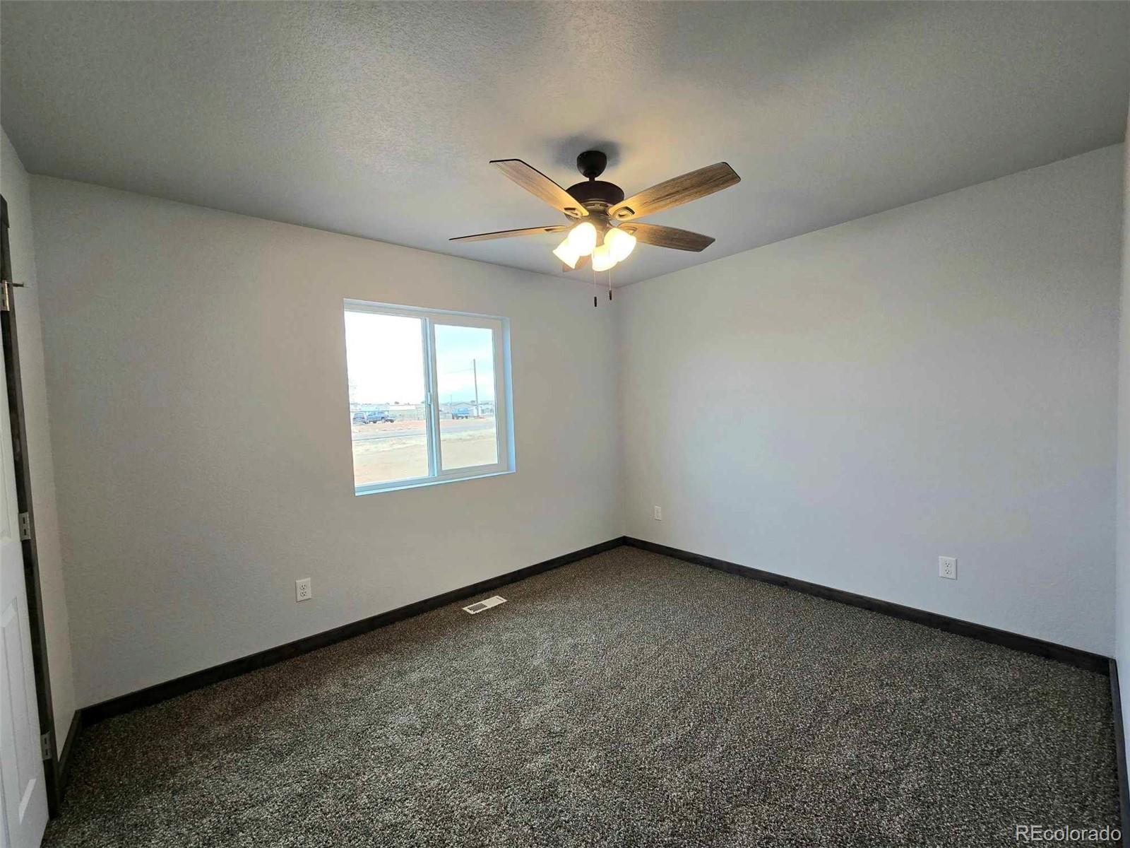 121 Quincy Street Florence, CO 81226 - Photo 19 of 23 an empty room with a window and a ceiling fan