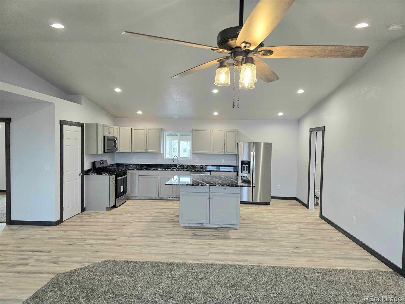 121 Quincy Street Florence, CO 81226 - Photo 3 of 23 a view of a kitchen with a sink stainless steel appliances and a ceiling fan