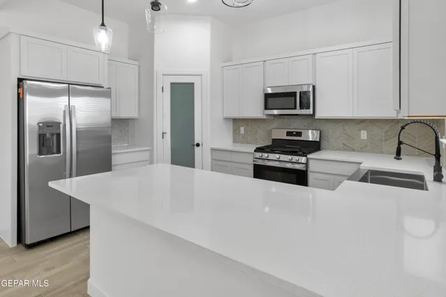 a kitchen with stainless steel appliances a refrigerator sink stove microwave and cabinets