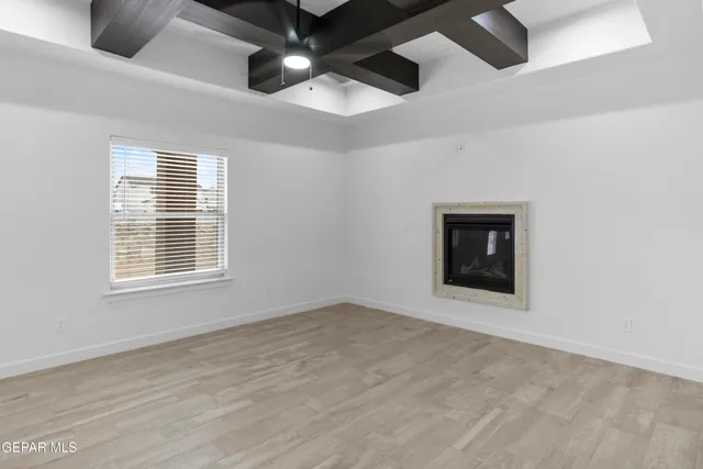 an empty room with ceiling fan and window