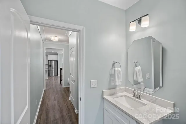 a en suite bathroom with a granite countertop sink and a mirror