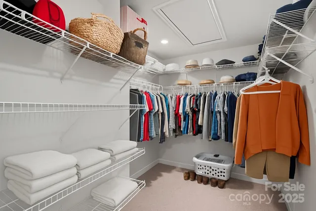 a view of walk in closet with clothes and shoes