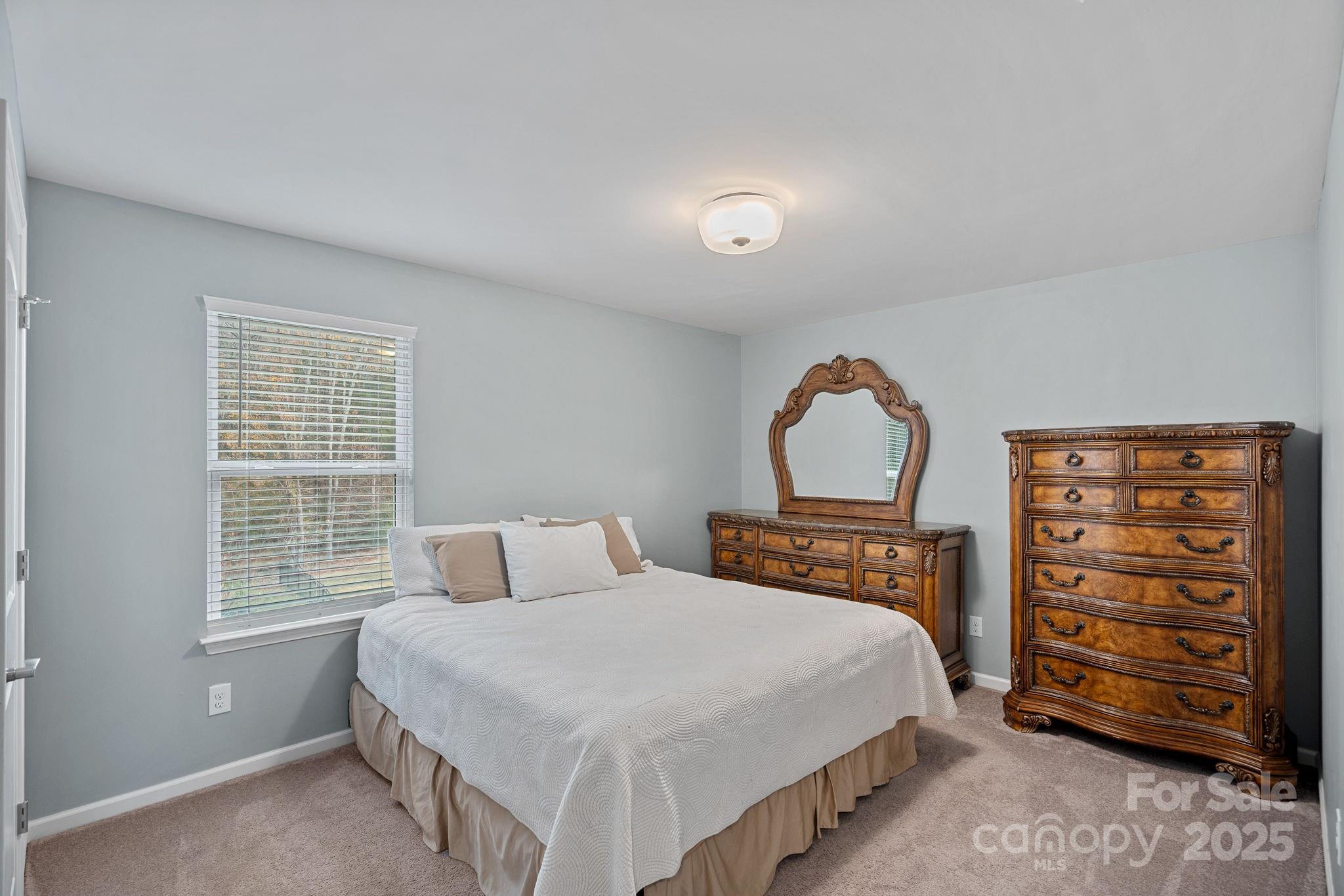 4780 Selhurst Drive Fort Mill, SC 29707 - Photo 19 of 34 a bedroom with a bed a dresser and a window
