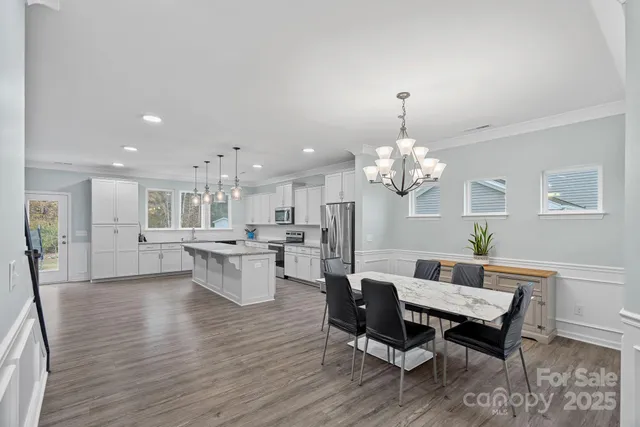 a view of a dining room with furniture wooden floor and a chandelier