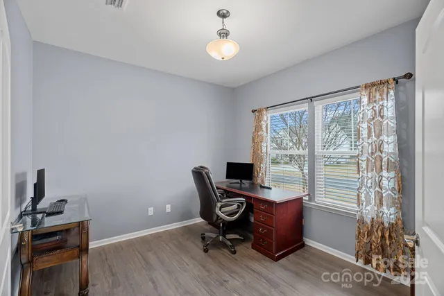 a view of a workspace with furniture and a window
