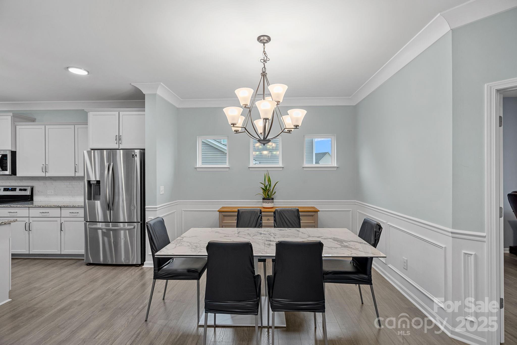 4780 Selhurst Drive Fort Mill, SC 29707 - Photo 5 of 34 a view of a dining room with furniture a chandelier and wooden floor