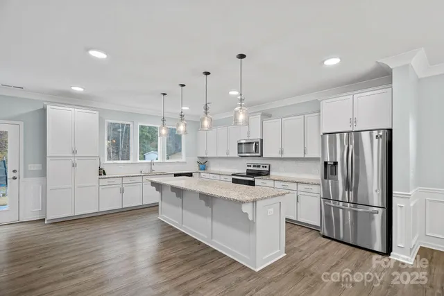 a kitchen with white cabinets and stainless steel appliances