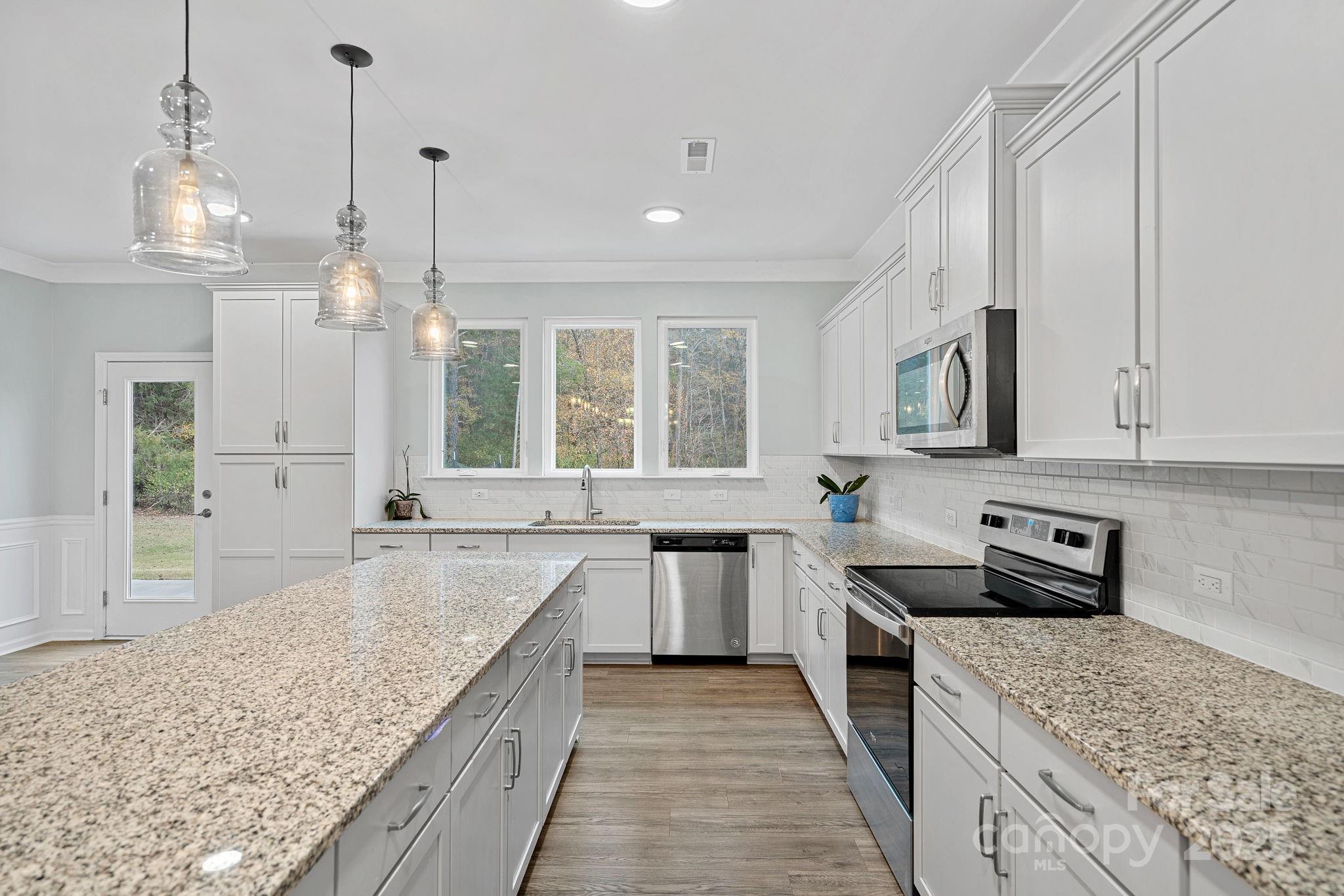 4780 Selhurst Drive Fort Mill, SC 29707 - Photo 7 of 34 a kitchen with stainless steel appliances granite countertop a sink stove and refrigerator