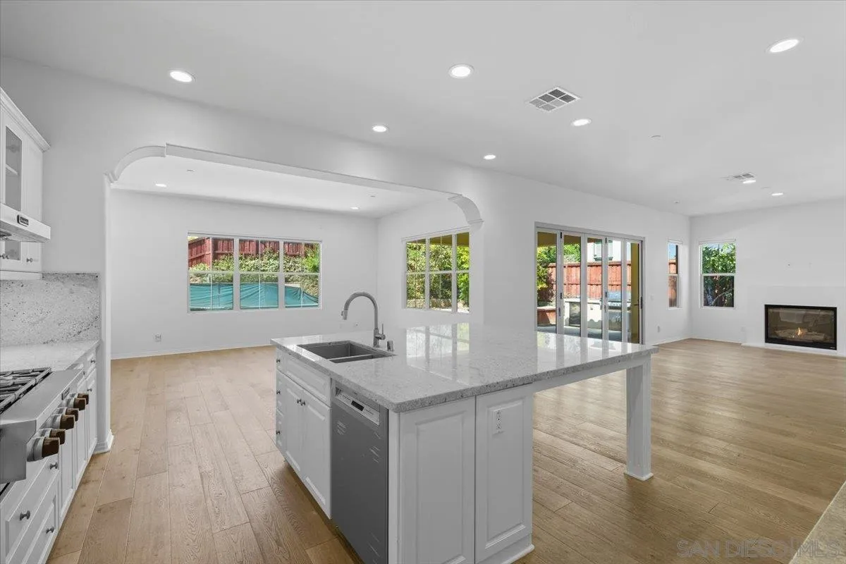4249 Peralta Street Carlsbad, CA 92010 - Photo 12 of 49 a kitchen with stainless steel appliances granite countertop a sink and a wooden floors