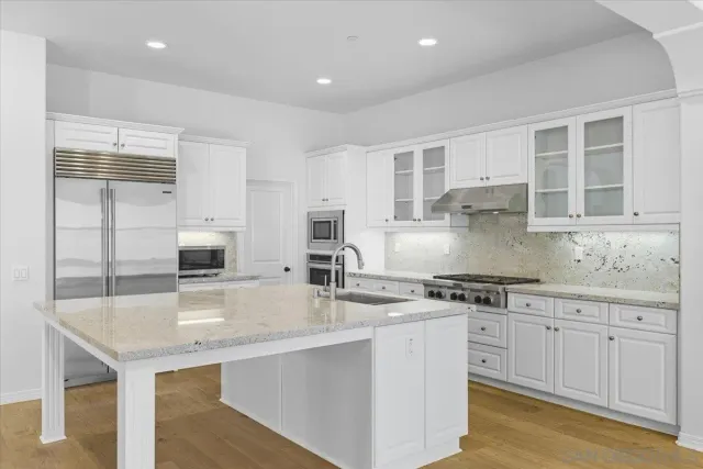 a kitchen with stainless steel appliances granite countertop a sink stove and cabinets