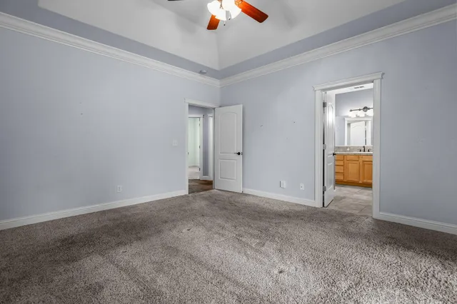 an empty room with closet and a chandelier fan