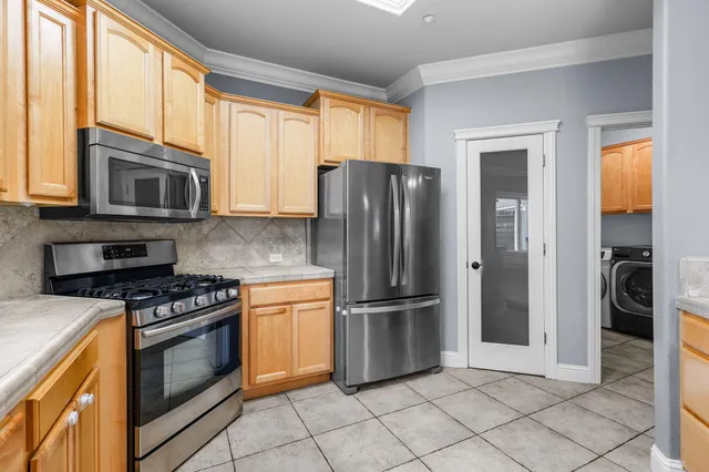 a kitchen with granite countertop a refrigerator and a stove top oven