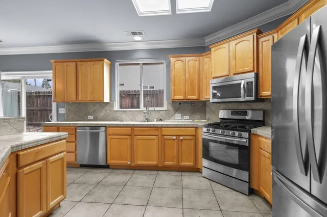 a kitchen with stainless steel appliances granite countertop a sink stove and refrigerator