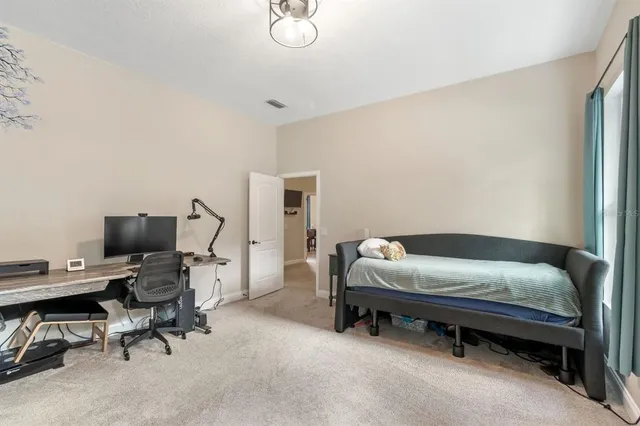 a bedroom with a bed a window and a flat screen television