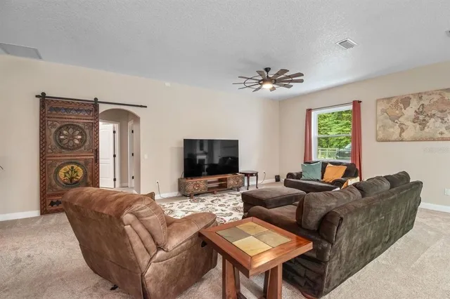 a dining room with wooden floor a chandelier a glass table and chairs
