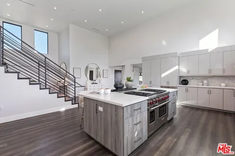 a kitchen with a sink stove top oven and cabinets