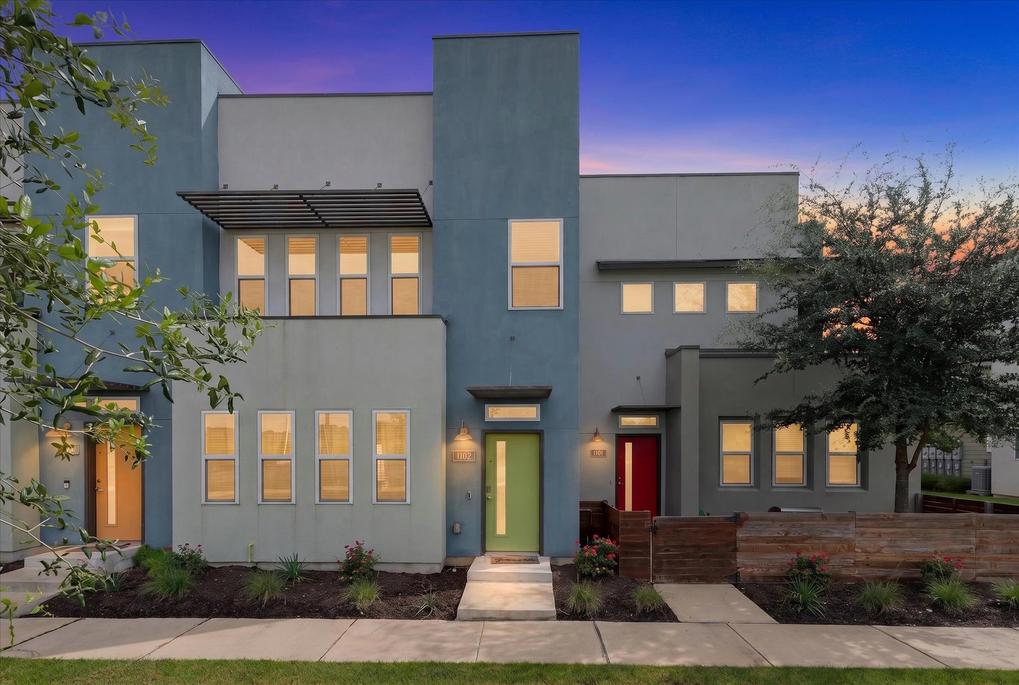 A modern townhouse complex showcases vibrant entry doors and clean architectural lines.