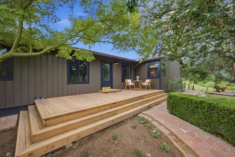 a view of a patio with table and chairs with wooden floor and fence