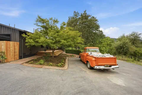 a view of a house with a yard and potted plants