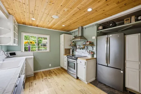 a kitchen with stainless steel appliances a sink cabinets and wooden floor