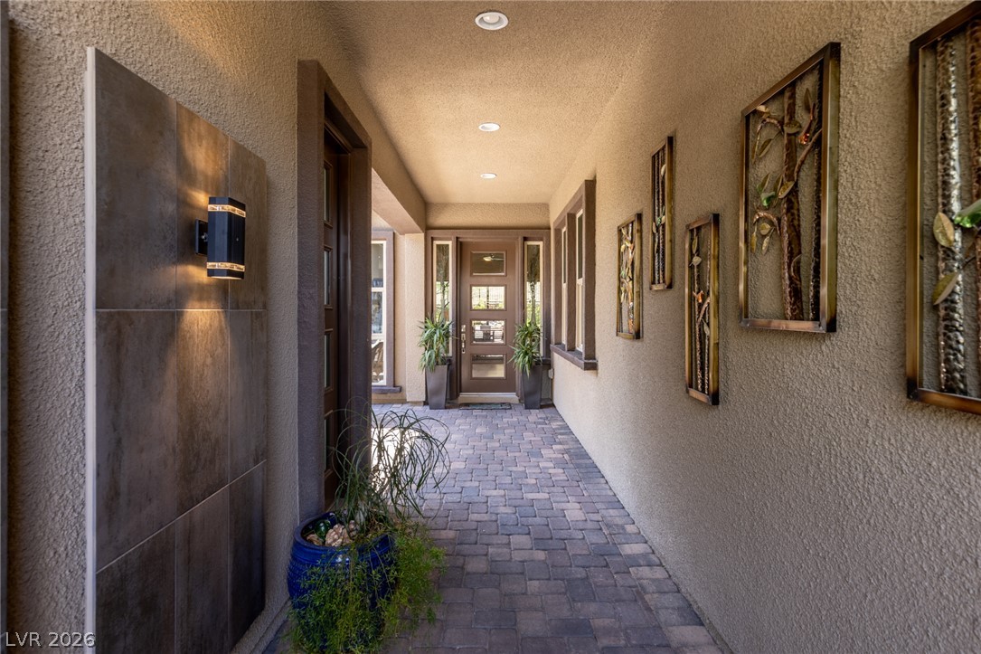 A welcoming entry path of pavers leads to a modern front door, flanked by contemporary sconce lighting.