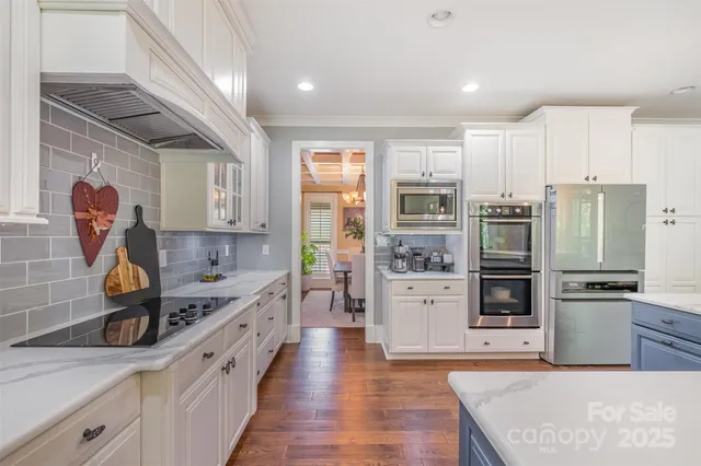 a kitchen with stainless steel appliances granite countertop a refrigerator and a stove top oven