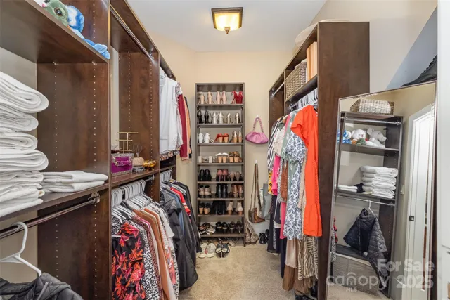 a view of walk in closet with clothes