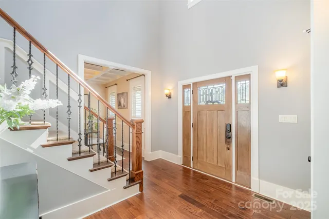 a view of front door with hallway and wooden floor