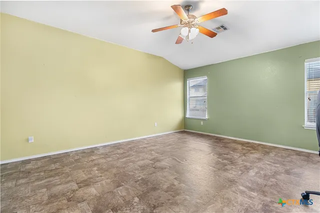 an empty room with a window and a ceiling fan