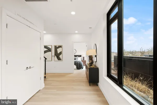 a view of a hallway with wooden floor and living room