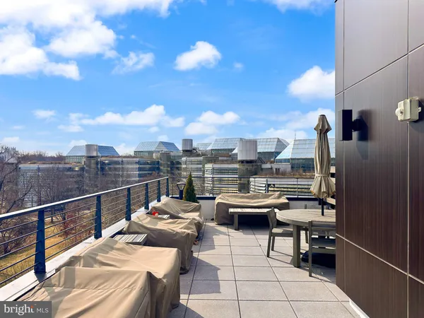 a view of a roof deck with couches and sky view