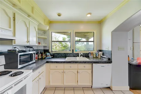 a kitchen with stainless steel appliances granite countertop a sink stove and cabinets