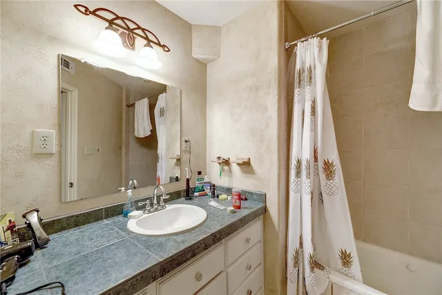 a bathroom with a granite countertop sink and a mirror