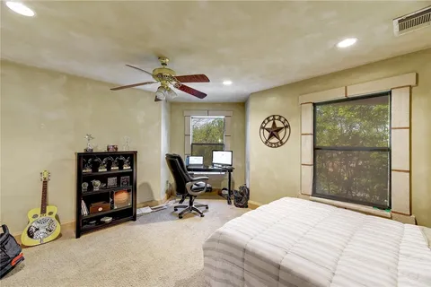 a bedroom with a bed a table and a large window