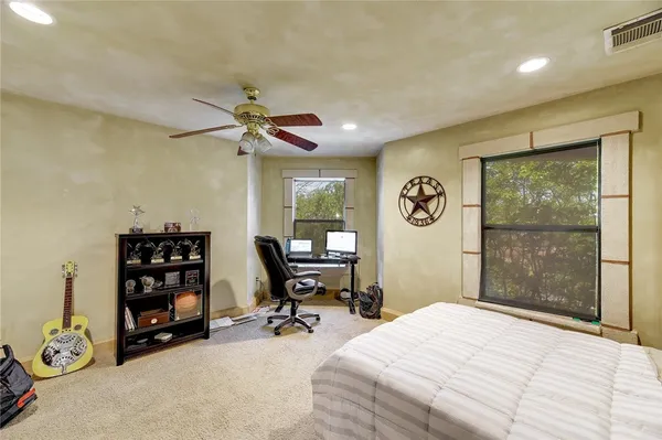 a bedroom with a bed a table and a large window