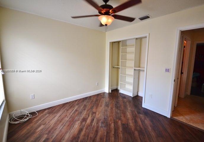 17569 North 89th Place North Loxahatchee, FL 33470 - Photo 20 of 24 an empty room with wooden floor a ceiling fan and closet